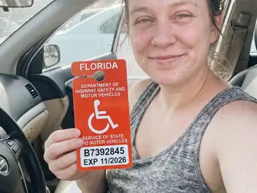 Expectant mother smiling in the driver seat of her car