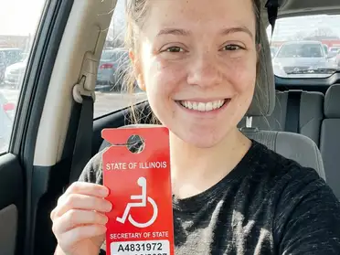 Happy Rocket Records customer holding a disability parking placard in her car