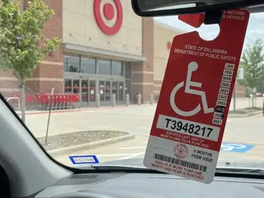 Expectant mother holding her disability parking permit