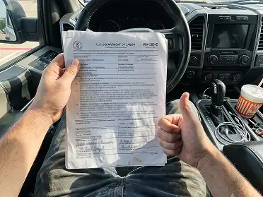 Andrew C. from Texas holding FMLA paperwork in his car
